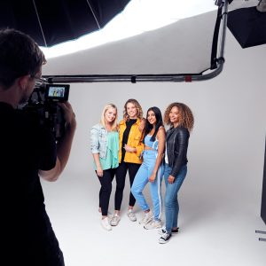 Group Studio Photo Shoot Of Young Multi-Cultural Female Friends Smiling And Laughing At Camera